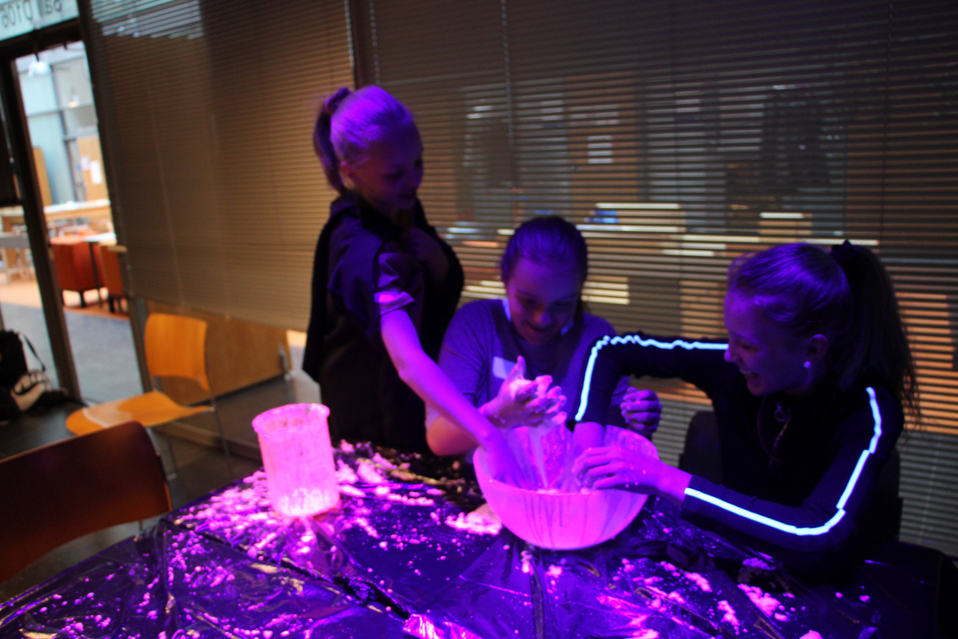 Girls doing chemistry experiments in UV-light